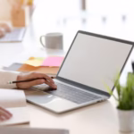 Osoba pracująca przy laptopie w biurze – wirtualne biuro Łódź, adres dla firm.