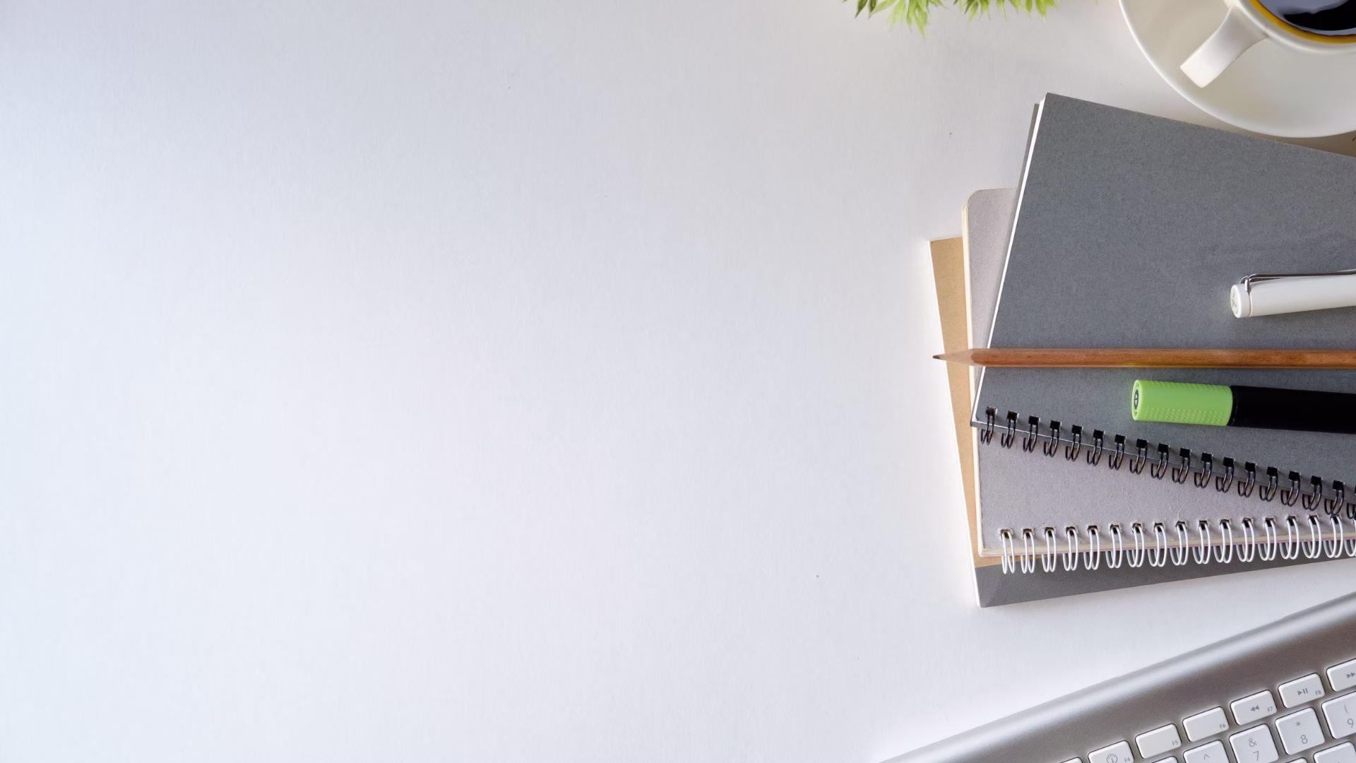 Notatniki, długopis i klawiatura – symbol pracy biurowej oraz zmiany adresu firmy na wirtualne biuro Łódź.